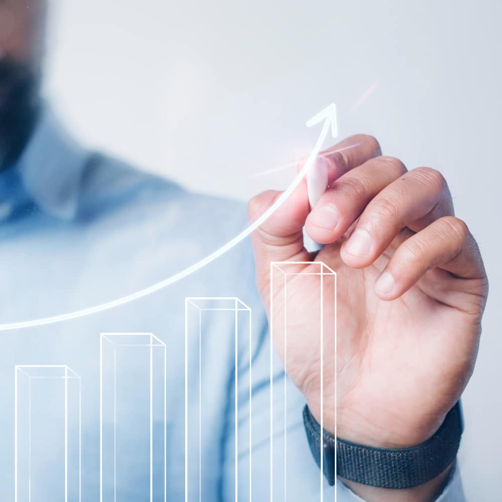 a man drawing a graph on a glass board